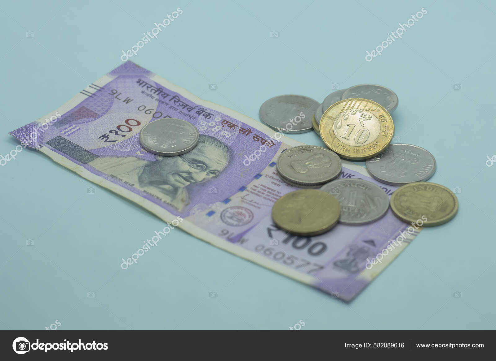 印度元100卢比的钞票与印度硬币蓝色底色的1 10卢比硬币——图库图片© wirestock_creators #582089616