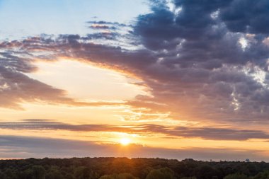 Yeşil sık ormanın üzerindeki büyüleyici gün batımı manzarası