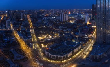 Modern yüksek binaların ve gece trafik yollarının olduğu güzel bir şehir manzarası.