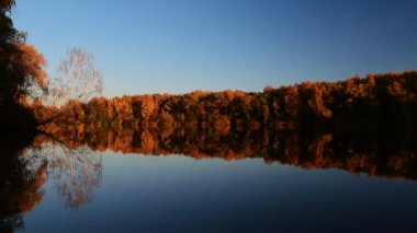 Göle yansıyan bazı sonbahar ağaçlarının perspektif görüntüsü.