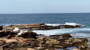 Bulutlu gökyüzünün altında güzel bir deniz manzarası var.