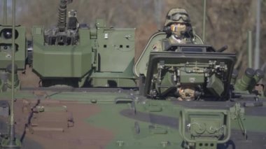 Ağır çekimde zırhlı araçlar, Romanya 'nın ulusal gününde askeri geçit töreninde kalabalığı selamlayan askerleri tepede gezdirdi.