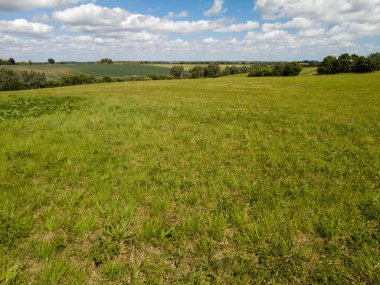 Gökyüzünün manzaralı bulutlu altında huzurlu yeşil bir manzara.