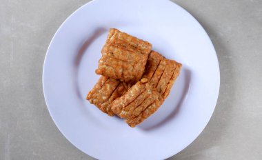 Beyaz bir tabakta geleneksel Endonezya usulü kızarmış tempo garit 'in yakın plan fotoğrafı.