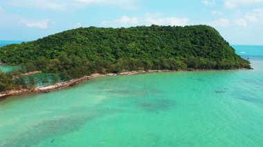 Tayland 'ın Ko Pha Ngan kentindeki Koh Ma Adası' nda mavi gökyüzünün altında güneşli yeşil bir tepe tatil köyü.