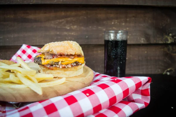 Kąt Ujęcia Hamburgera Drewnianym Talerzu Cebulowymi Krążkami Frytkami Obok Szklanki — Zdjęcie stockowe