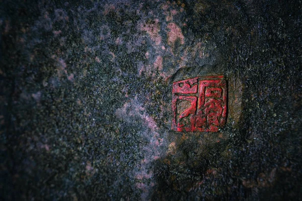 A with Chinese style seal on a mossy rock with a copy space