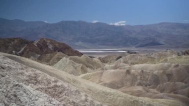 Mavi gökyüzüne karşı güzel, dağlık bir manzaranın büyüleyici görüntüsü.