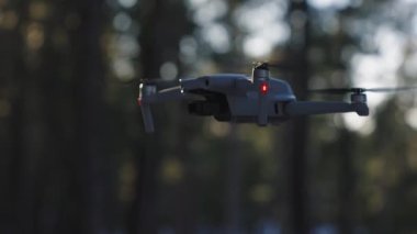 Bulanık bir arka planda havada uçan bir dronun görüntüsü.