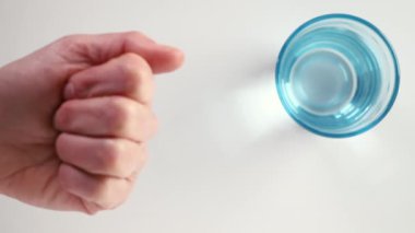 Beyaz arka planda beyaz hapları olan kadın eli, kapanıyor. ,