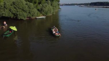 Güneşli bir günde Tuna Nehri 'nde bir teknede dinlenen insanların insansız hava aracı görüntüsü.