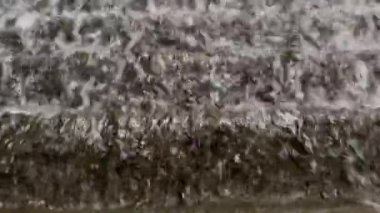 Şelaleden göle atlayan suyun yakın çekim görüntüsü.