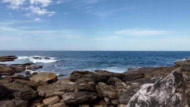 Bulutlu gökyüzünün altında güzel bir deniz manzarası var.