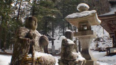Japonya 'da kış boyunca bir sıra eski taş Buddah heykelleri