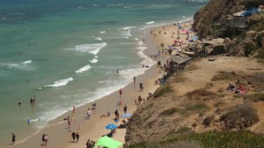 İnsanlar Sydney Ali 'de bir uçurumdan yürüyor, yüzüyor, sahilde ve denizde oynuyorlar.