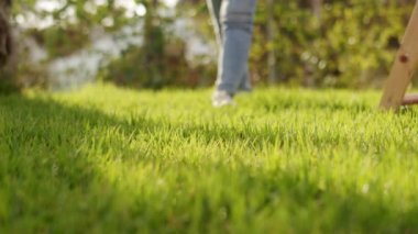 Çıplak ayaklı bir çocuk çimenlerde yürüyor.