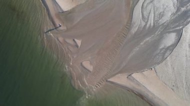 Polonya 'nın Gdansk kentindeki Jelitkowo Sahili' nde Baltık Denizi 'ne akan bir nehrin hava görüntüsü.