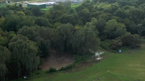 从空中俯瞰穿过田野绿树的河流 — 图库视频影像