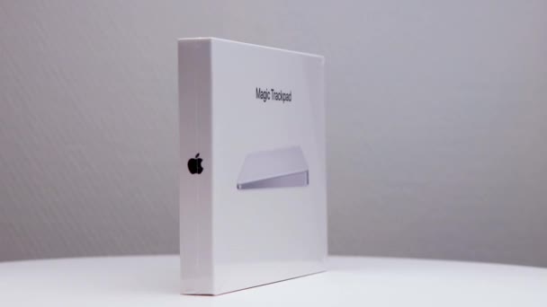 展台上摆放着装有苹果公司标志的Macmagic Trackpad左轮白色包装盒 侧面可见 — 图库视频影像