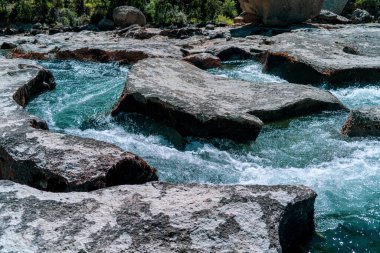 A scenic view of a river flowing through rocky banks on a sunny day