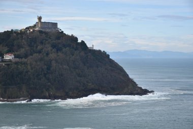 Bazı binalar deniz kıyısındaki büyük bir uçurumda ağaçlarla çevrilidir..
