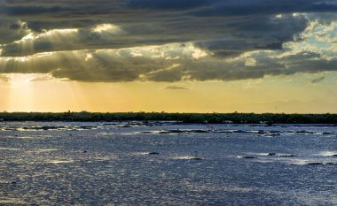 Güzel nefes kesici bir göl manzarası ve bulutlu bir gökyüzü.