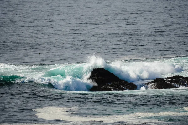 海浪冲击着布满青苔的岩石 造成了气泡 — 图库照片