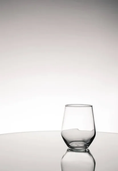 Een Grijswaarden Shot Van Leeg Glas Met Reflectie Tafel — Stockfoto