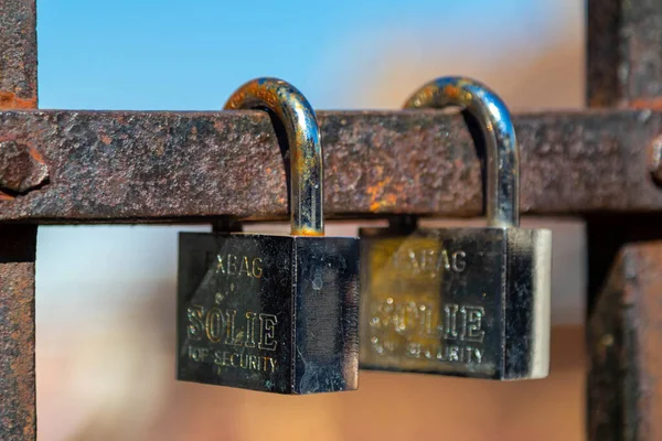 錆びた金属製の棒に隔離された2つの銀製の閉じた南京錠の閉鎖 — ストック写真