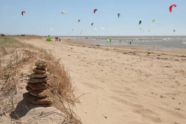 Tiro Foco Seletivo Pedras Empilhadas Uma Praia Areia Com Kitesurfers — Fotografia de Stock