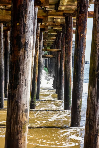 Vertical Shot Wooden Pillars Deck Waves Washing Sandy Coast — Stock Photo, Image