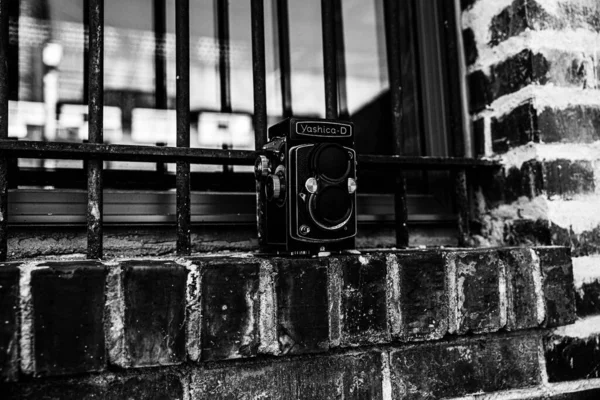 Strzał Skali Szarości Zabytkowej Kamery Zamkniętym Oknie Ceglanym Budynku — Zdjęcie stockowe
