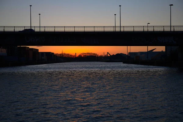 Een Silhouet Van Een Brug Een Rivier Zonsondergang — Stockfoto