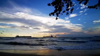 Rüzgarlı bir günde gün batımında kumsalda nefes kesici bir deniz dalgası manzarası.