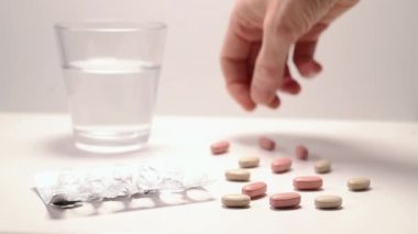 Beyaz arka planda haplar ve su bardakları, çeşitli renkli haplar ve masa, ocak bakımı ve ilaç boş su toplayıcıları.