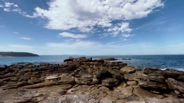 Bulutlu gökyüzünün altında güzel bir deniz manzarası var.