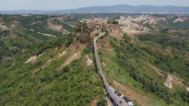 İtalya 'da yeşil orman ve tepelerle çevrili küçük bir şehrin hava görüntüsü.