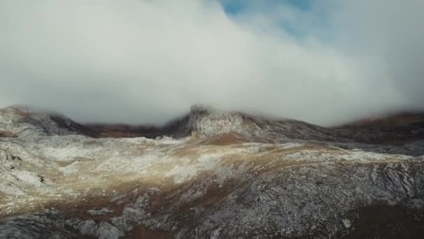 雲に覆われた寒い雪の天気の山のピークの空中ショット — ストック動画