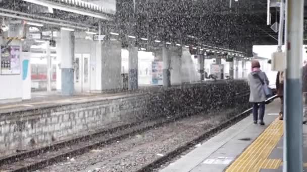 降雪時に黄色の車線を歩いている古い鉄道駅 — ストック動画