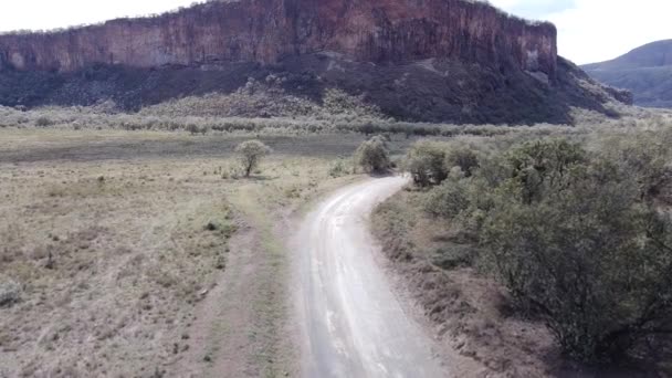 ケニアのナイバシャの丘陵地帯を走行する車のドローン映像 — ストック動画