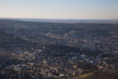 Gökyüzünün altında yoğun binalar ve ağaçlarla dolu Stuttgart manzaralı bir şehir.