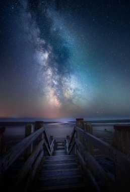 A path leading to the Camber sands beach. Magic nightscape with Milky way in the starry sky in the background, UK clipart