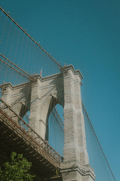 A vertical shot of a bridge under a bright sky