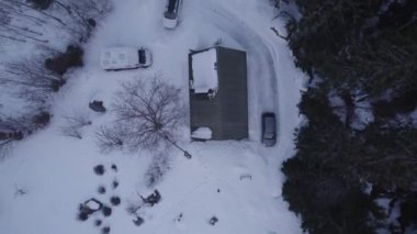 Kış ormanlarında karla kaplı ev ve arabaların hava manzarası