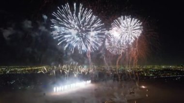 Karanlık bir gecede Suudi Arabistan 'ın arka planında şehir ışıkları olan güzel havai fişeklerin hava görüntüsü.
