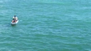 Sakin, mavi sularıyla okyanusta kanoda bir balıkçı.