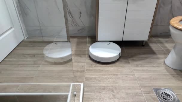 Egy Fehér Robot Porszívó Porszívózik Fürdőszobában — Stock videók