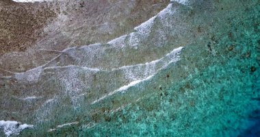 Kıyı şeridini kaplayan dalgaların hava görüntüsü.