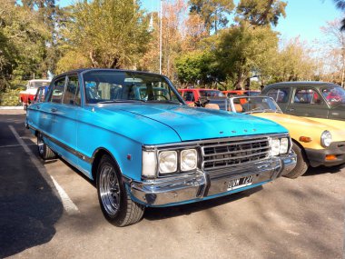 Quilmes, Arjantin - 29 Mayıs 2022: Eski gökyüzü mavisi Şahin dört kapılı 1970 'ler bir parkta. Doğa, ağaçlar. Klasik araba şovu.