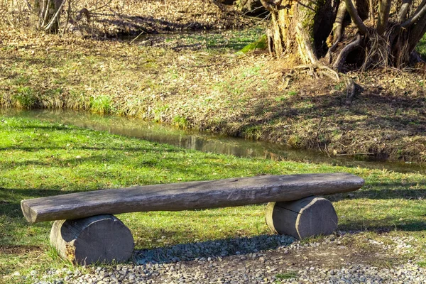 木のベンチは板で作られ 小さな小川で森の中に記録されます — ストック写真